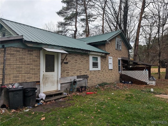 3831 Creek Rd, Yorkshire, NY 14030 - rear view of house featuring entry steps, brick siding, a lawn, and metal roof