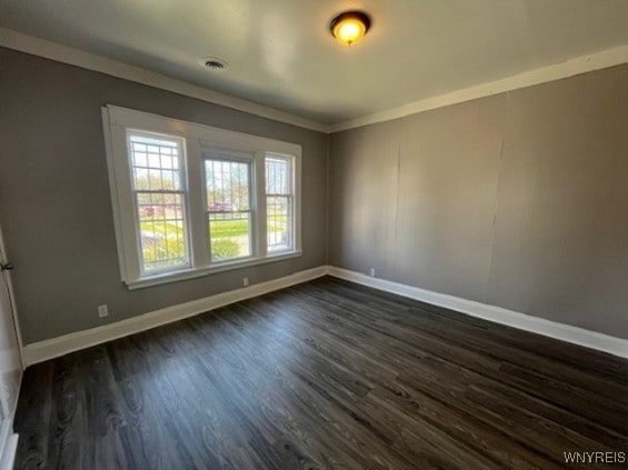 empty room featuring dark hardwood / wood-style floors and crown molding