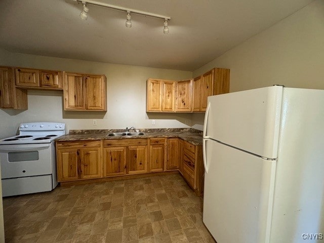 kitchen featuring white appliances, sink, and track lighting