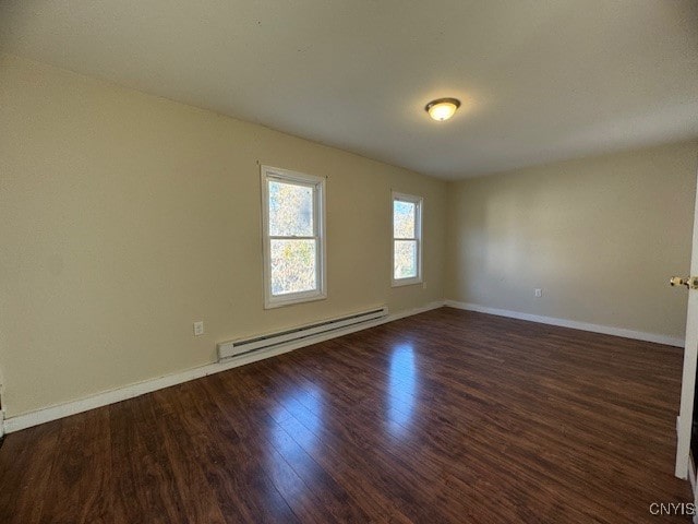 spare room with a baseboard radiator and dark hardwood / wood-style flooring