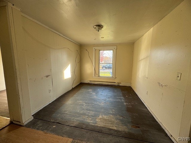 spare room featuring dark hardwood / wood-style floors and a baseboard heating unit