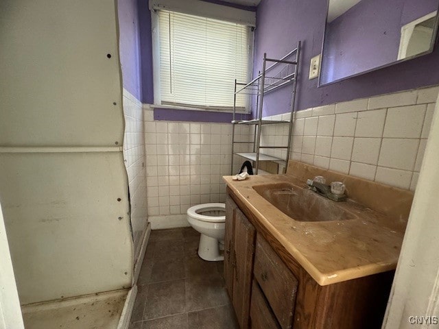 bathroom with vanity, tile patterned flooring, toilet, and tile walls