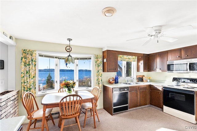 kitchen with white electric range oven, a water view, plenty of natural light, decorative light fixtures, and black dishwasher