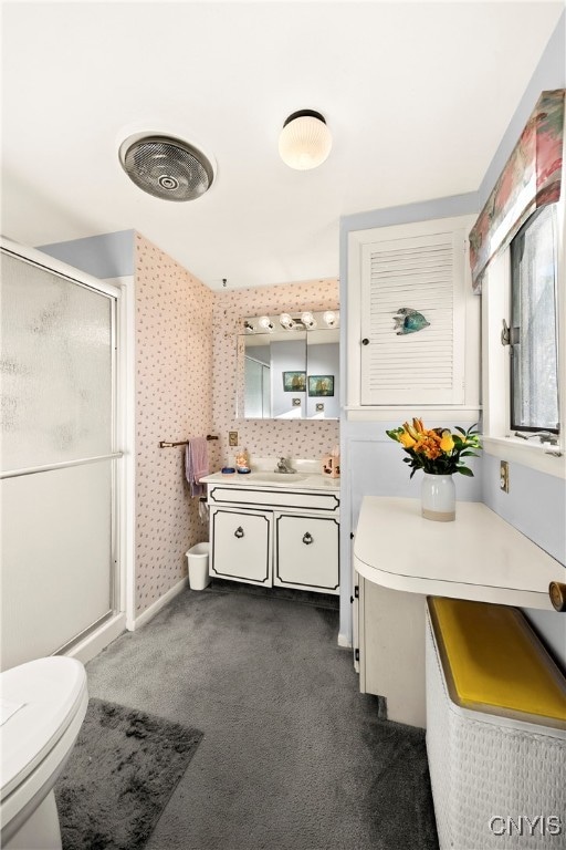 bathroom with walk in shower, vanity, and toilet