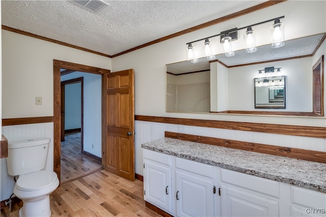 bathroom featuring vanity, a textured ceiling, hardwood / wood-style flooring, and crown molding