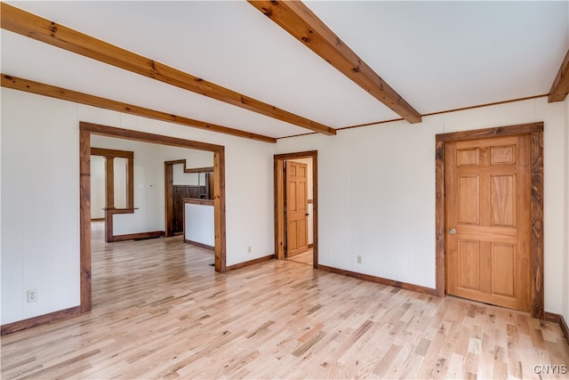 unfurnished room featuring light wood-type flooring and beam ceiling