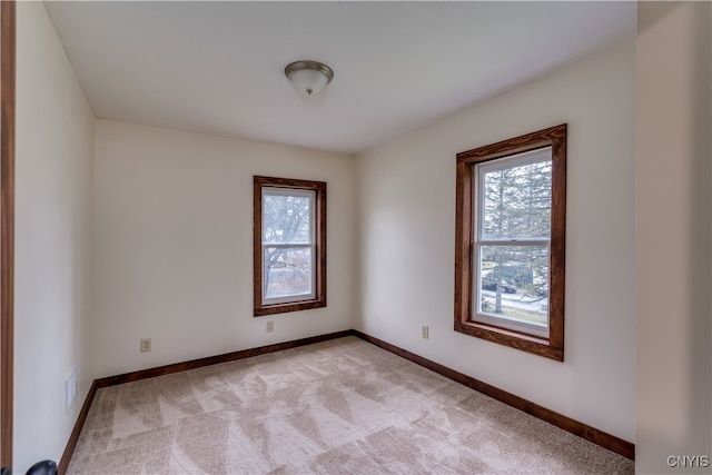 spare room featuring light colored carpet