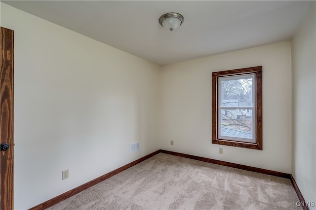 spare room featuring light carpet