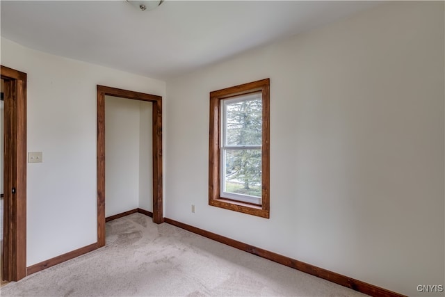 unfurnished bedroom featuring a closet and light carpet