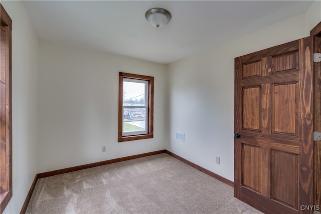 spare room featuring light colored carpet