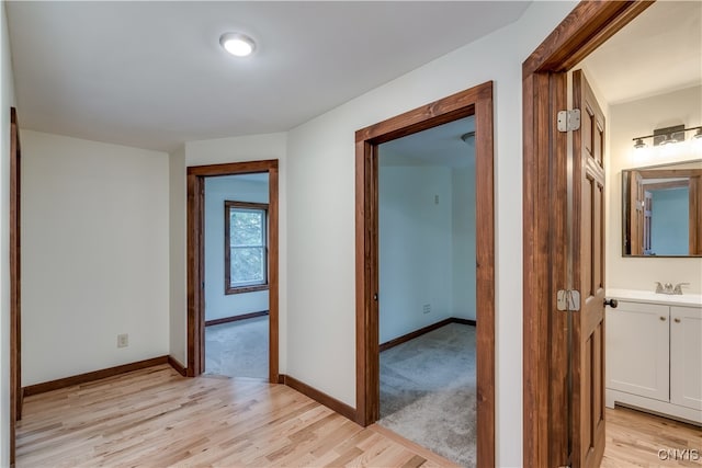 hall with light hardwood / wood-style floors and sink