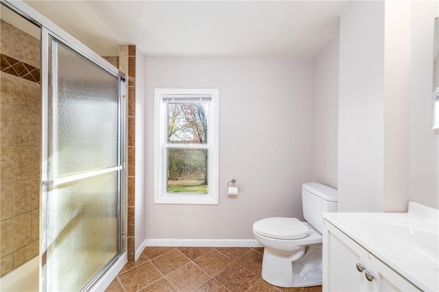 full bath with toilet, tile patterned floors, a stall shower, vanity, and baseboards