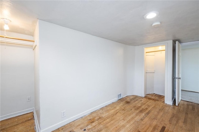 unfurnished bedroom featuring recessed lighting, baseboards, visible vents, and hardwood / wood-style flooring