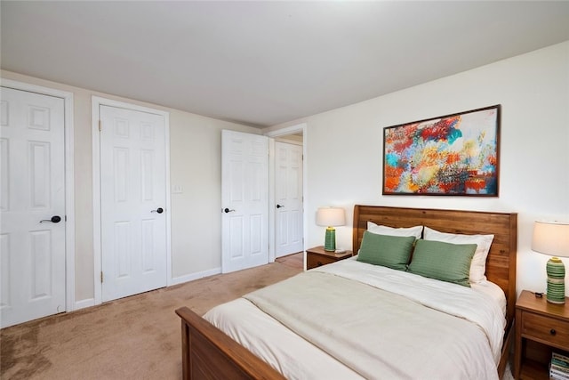 bedroom with light colored carpet and baseboards