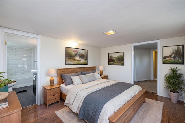bedroom with ensuite bathroom and dark wood-type flooring