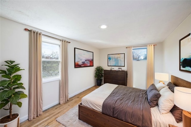 bedroom with recessed lighting, light wood-type flooring, and baseboards