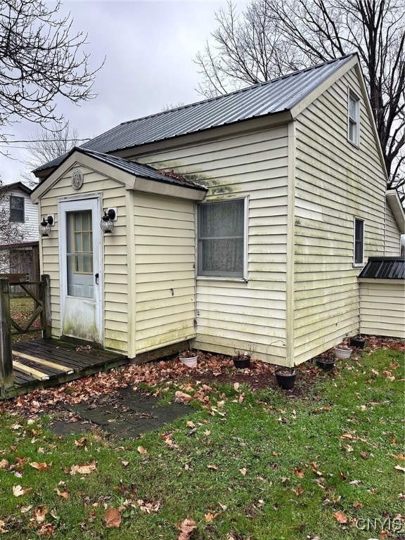 back of house featuring a wooden deck and a yard