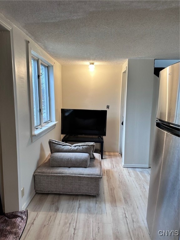 sitting room featuring a textured ceiling and light wood-type flooring