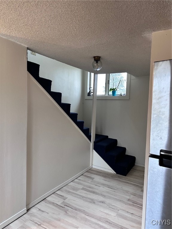 stairs with hardwood / wood-style floors and a textured ceiling