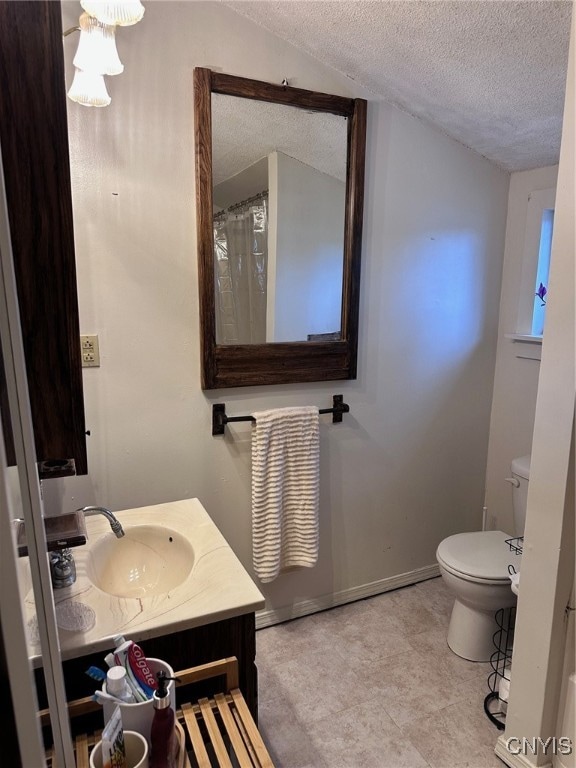 bathroom with vanity, a textured ceiling, and toilet