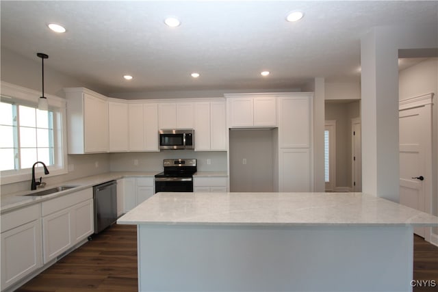 kitchen featuring white cabinetry, light stone countertops, appliances with stainless steel finishes, and sink