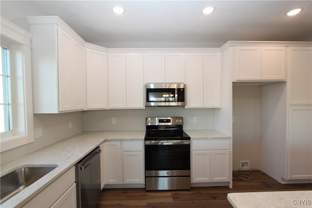 kitchen with white cabinets, a wealth of natural light, appliances with stainless steel finishes, and light stone countertops