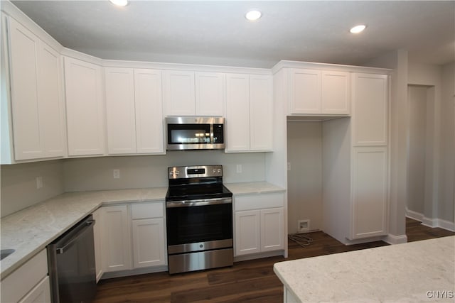 kitchen with stainless steel appliances, light stone countertops, white cabinetry, and dark hardwood / wood-style flooring