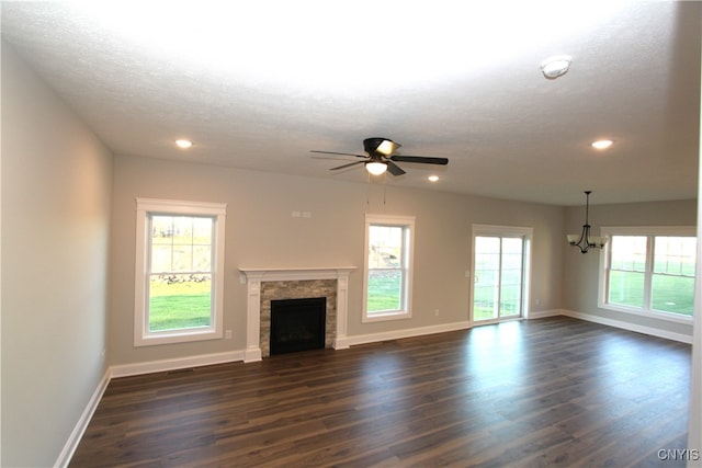 unfurnished living room featuring dark wood-type flooring, a wealth of natural light, and a tile fireplace