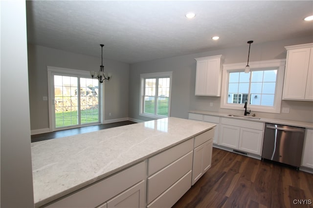 kitchen with pendant lighting, stainless steel dishwasher, and light stone counters