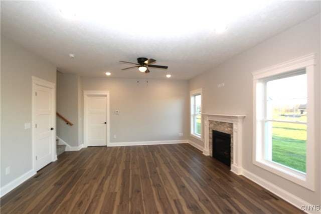 unfurnished living room featuring dark wood-type flooring, ceiling fan, and a healthy amount of sunlight