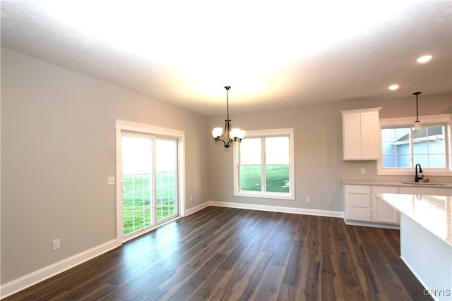 kitchen featuring dark hardwood / wood-style flooring, a wealth of natural light, hanging light fixtures, and white cabinets