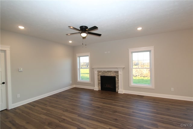 unfurnished living room with dark hardwood / wood-style flooring and ceiling fan