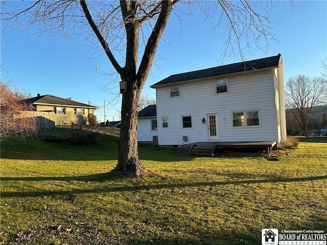 rear view of house featuring a yard