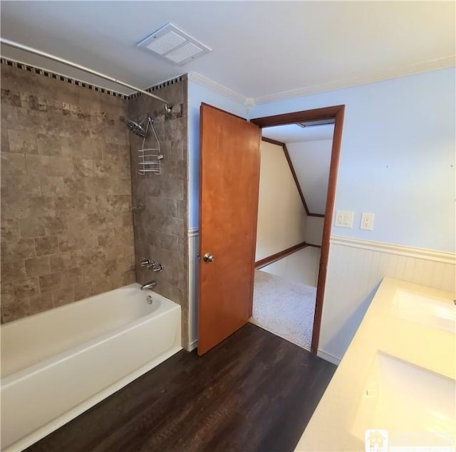 bathroom featuring vanity, tiled shower / bath combo, and wood-type flooring