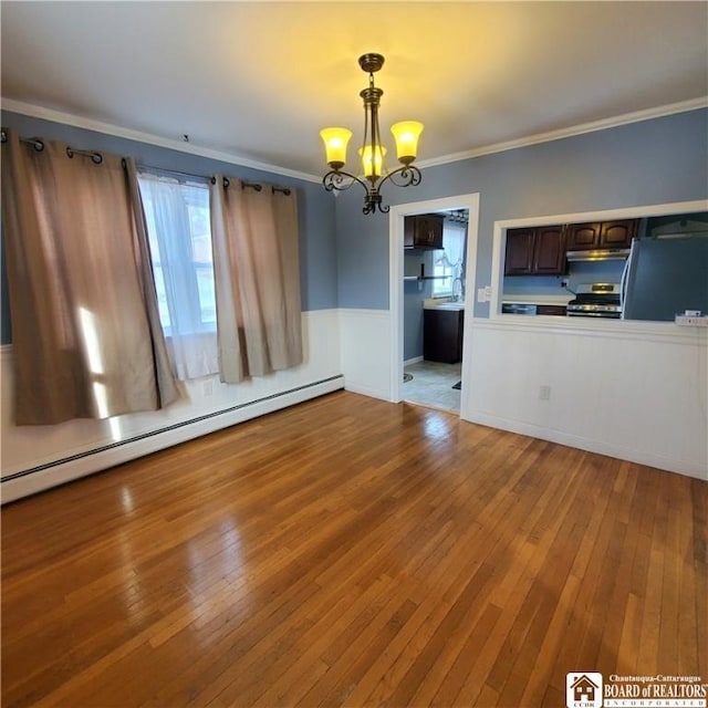 unfurnished living room featuring ornamental molding, a chandelier, hardwood / wood-style floors, and a baseboard heating unit