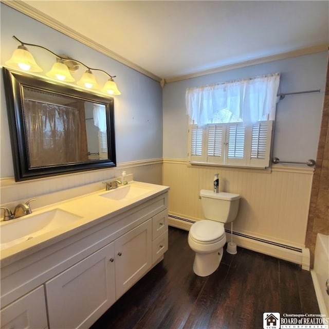 bathroom with wood-type flooring, toilet, vanity, and a baseboard heating unit