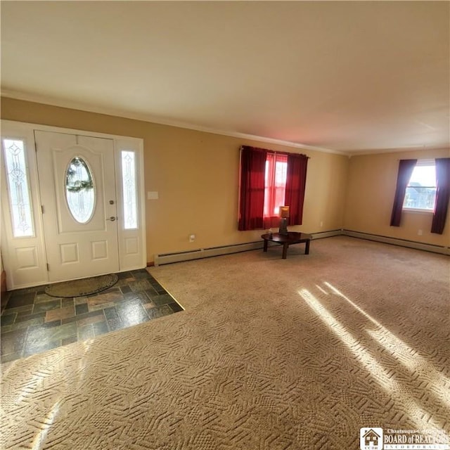 foyer entrance featuring baseboard heating, crown molding, and dark colored carpet