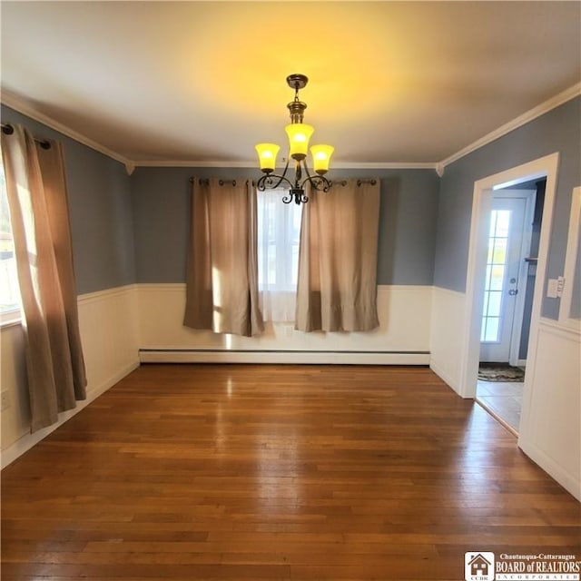 spare room with crown molding, dark wood-type flooring, plenty of natural light, and baseboard heating