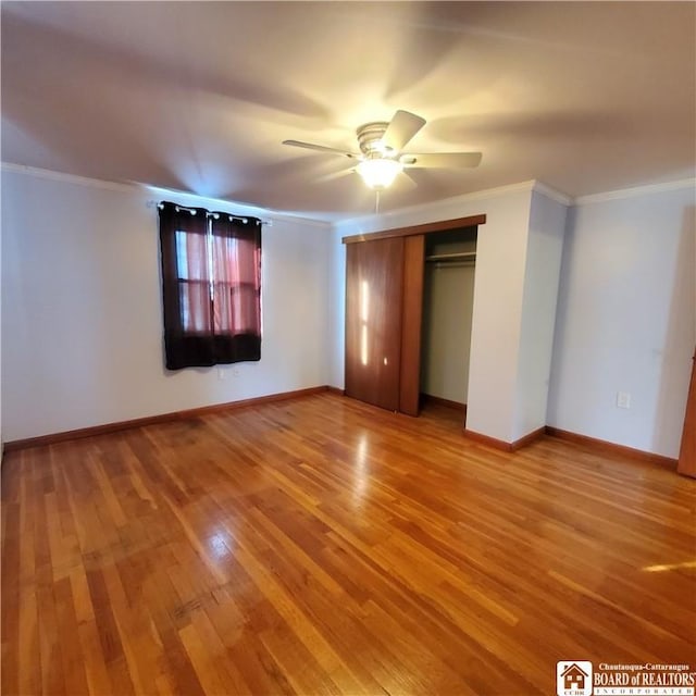 unfurnished bedroom featuring crown molding, ceiling fan, hardwood / wood-style floors, and a closet