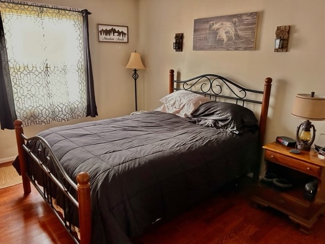 bedroom with dark wood-type flooring