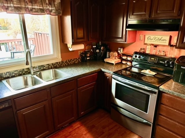 kitchen featuring dark wood-type flooring, sink, stainless steel range with electric stovetop, and dishwasher