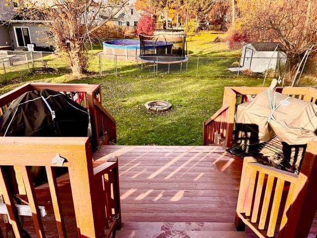 wooden terrace featuring a shed and a yard