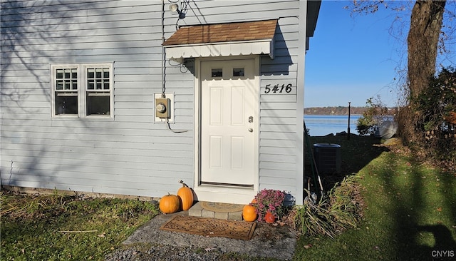 entrance to property with a water view and cooling unit