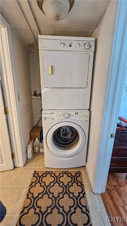 laundry area featuring light tile patterned floors and stacked washer / dryer