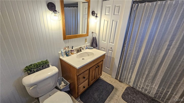 bathroom with a shower with curtain, tile patterned flooring, vanity, and toilet