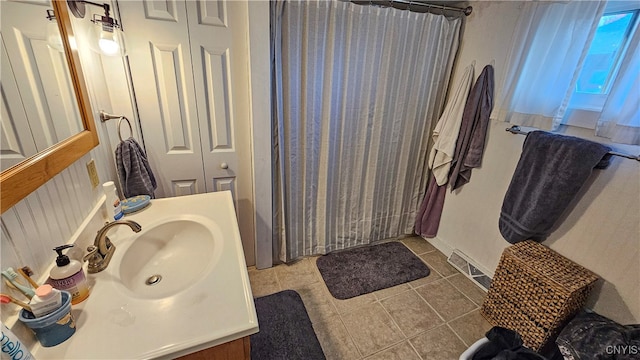 bathroom with curtained shower, vanity, and tile patterned floors