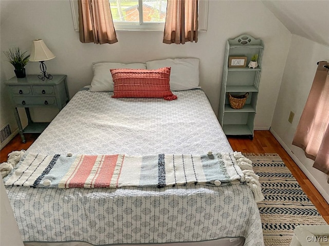 bedroom with dark hardwood / wood-style floors and vaulted ceiling