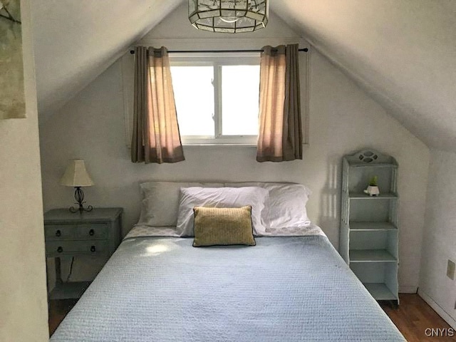 bedroom with lofted ceiling and hardwood / wood-style floors