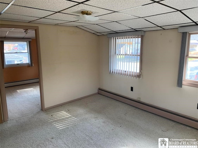 unfurnished room with a paneled ceiling, light colored carpet, and baseboard heating