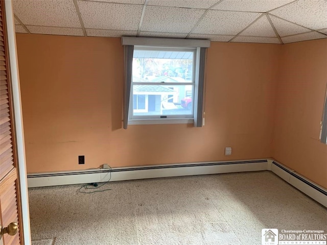 carpeted spare room featuring a paneled ceiling